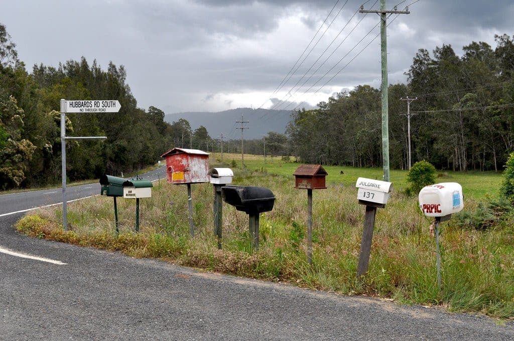 A row of weathered rural roadside mailboxes
