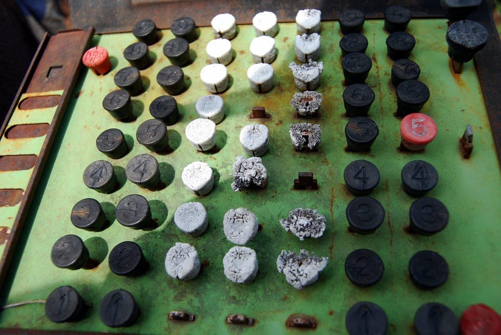 A rusted, decayed antique cash register